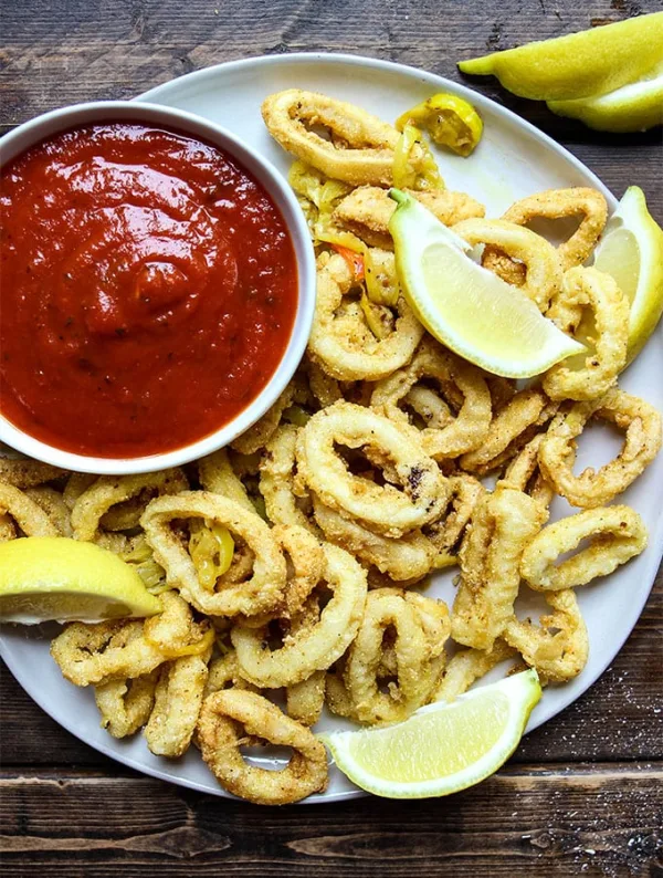 Rhode Island style calamari is deep fried to a delicious crispiness, then tossed with garlicy butter and hot banana pepper rings!